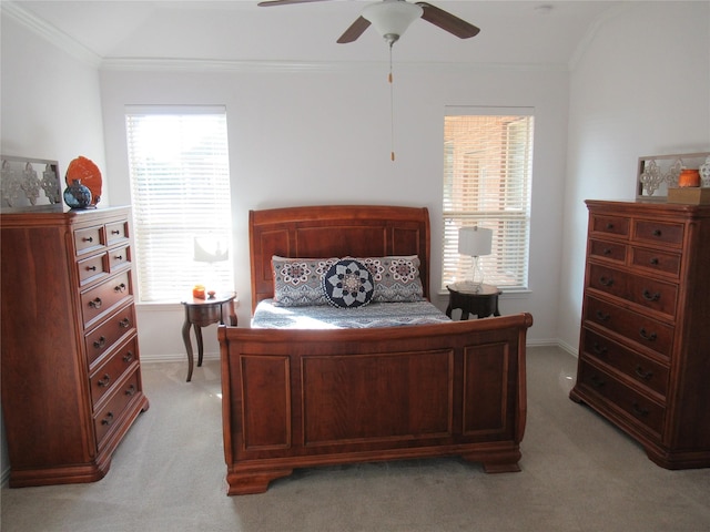 bedroom featuring ornamental molding, light colored carpet, and ceiling fan