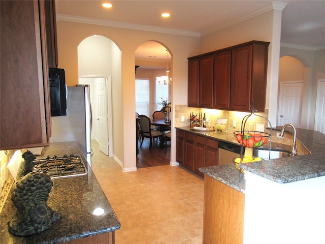 kitchen featuring appliances with stainless steel finishes, sink, dark stone countertops, and decorative backsplash