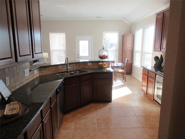 kitchen featuring light tile patterned flooring, sink, dark stone countertops, stainless steel dishwasher, and backsplash