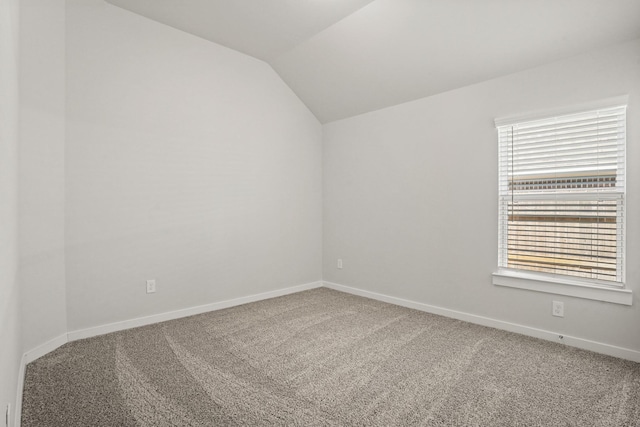 carpeted spare room with lofted ceiling