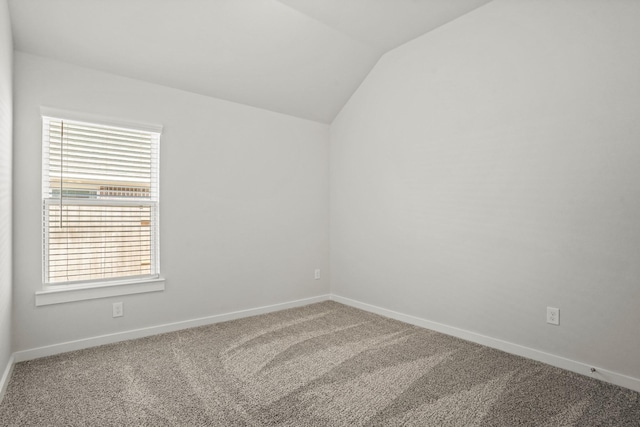 unfurnished room featuring carpet and lofted ceiling