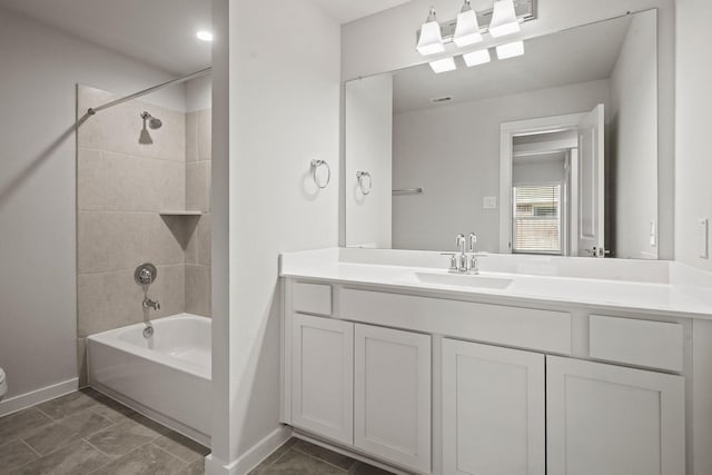 full bathroom with tiled shower / bath, vanity, and toilet