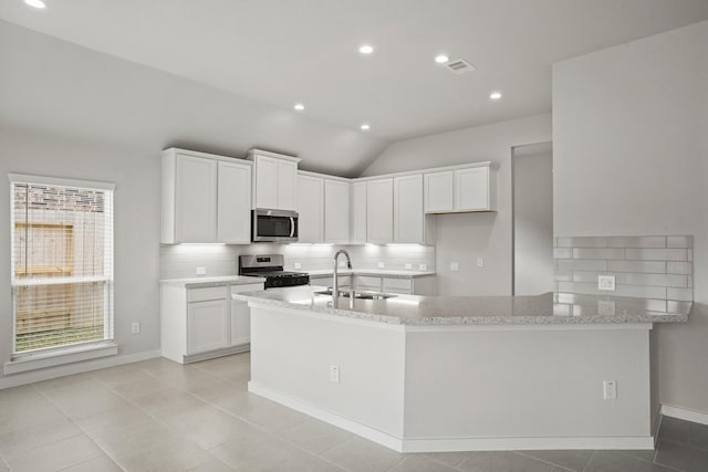 kitchen with white cabinetry, sink, backsplash, stainless steel appliances, and light stone countertops