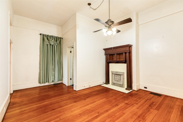 1428 Ball, Galveston, TX 77550 - unfurnished living room featuring a brick fireplace, light wood-type flooring, ceiling fan, and baseboards
