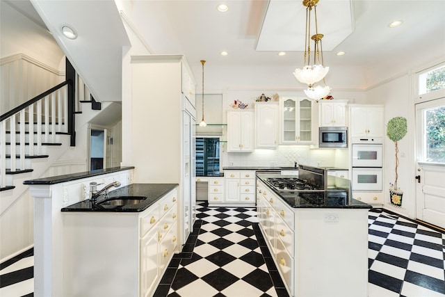 1428 Ball, Galveston, TX 77550 - kitchen with appliances with stainless steel finishes, dark floors, a sink, white cabinetry, and recessed lighting