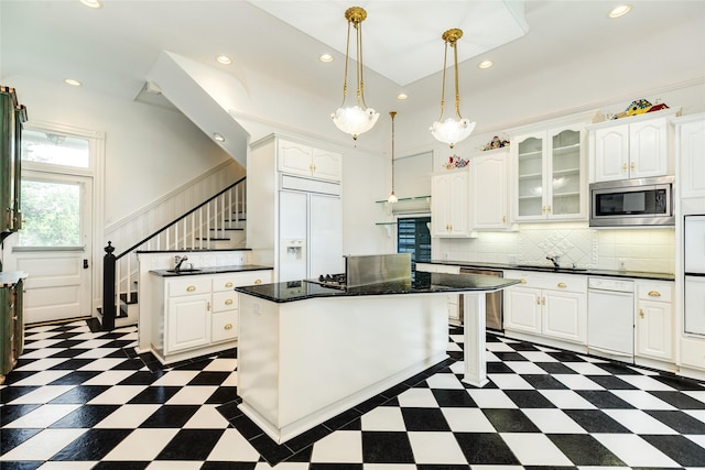 1428 Ball, Galveston, TX 77550 - kitchen featuring built in appliances, a kitchen island, dark countertops, white cabinetry, and dark floors