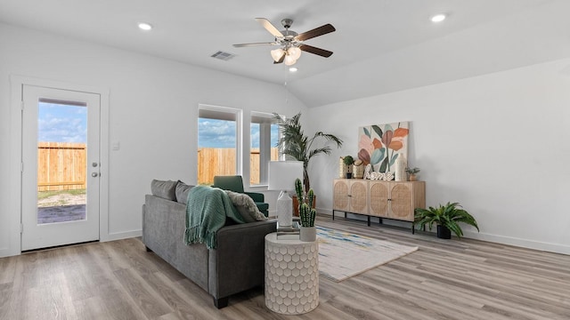 living room with hardwood / wood-style flooring, vaulted ceiling, and ceiling fan