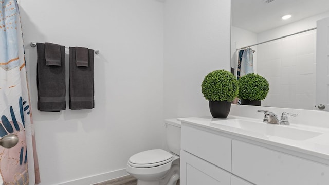 bathroom featuring vanity, wood-type flooring, toilet, and walk in shower