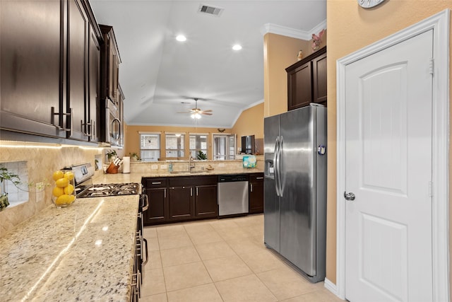 kitchen featuring visible vents, lofted ceiling, ornamental molding, stainless steel appliances, and a sink