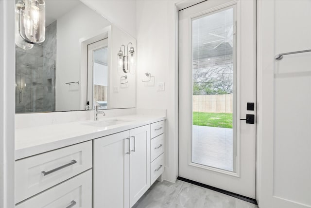 bathroom featuring a shower with shower door and vanity