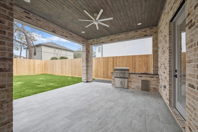 view of patio / terrace featuring ceiling fan, area for grilling, and exterior kitchen