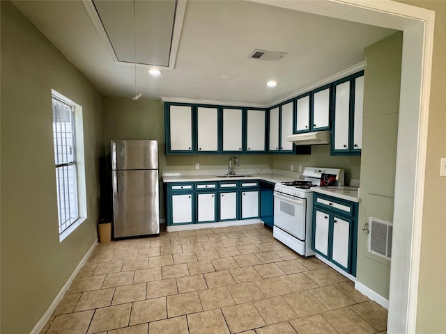 kitchen featuring white gas range, sink, light tile patterned floors, and stainless steel fridge