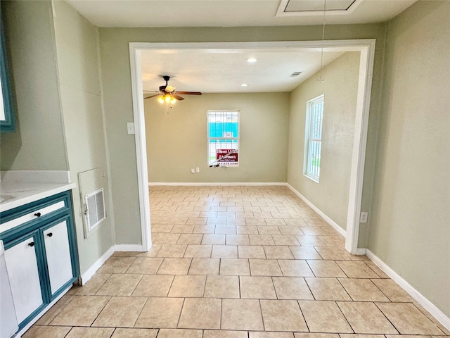 unfurnished living room with light tile patterned flooring and ceiling fan