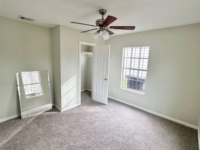 unfurnished bedroom featuring ceiling fan, carpet, a textured ceiling, and a closet