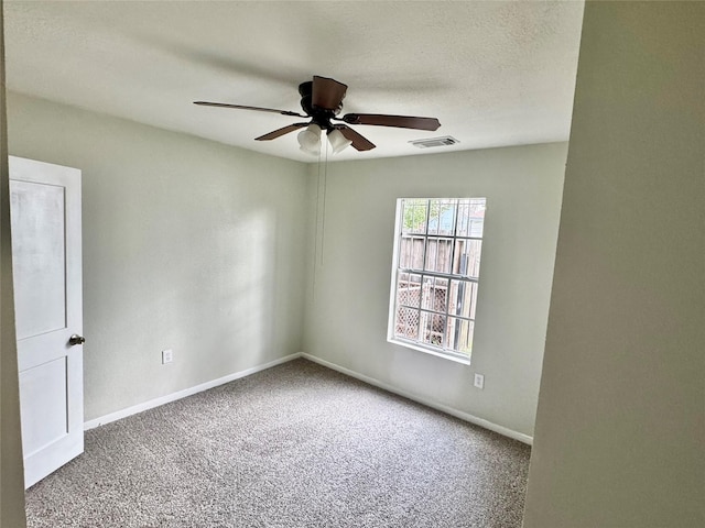 carpeted empty room with ceiling fan and a textured ceiling