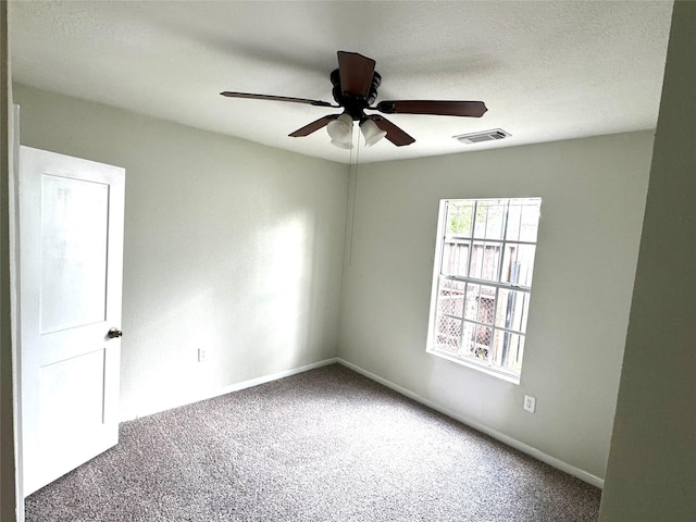 carpeted spare room with ceiling fan and a textured ceiling