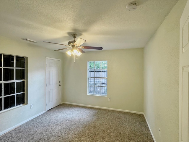 carpeted empty room featuring ceiling fan and a textured ceiling