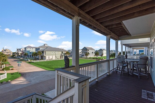 11446 Sea Butterfly, Galveston, TX 77554 - wooden terrace featuring a residential view, a lawn, and outdoor dining space