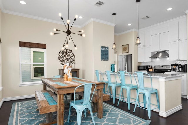 11446 Sea Butterfly, Galveston, TX 77554 - dining area featuring a chandelier, dark wood-type flooring, ornamental molding, baseboards, and recessed lighting