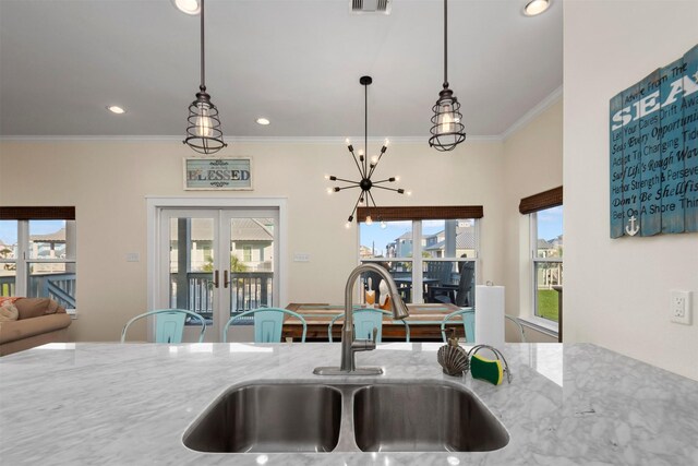11446 Sea Butterfly, Galveston, TX 77554 - kitchen featuring a sink, light stone countertops, crown molding, a chandelier, and pendant lighting