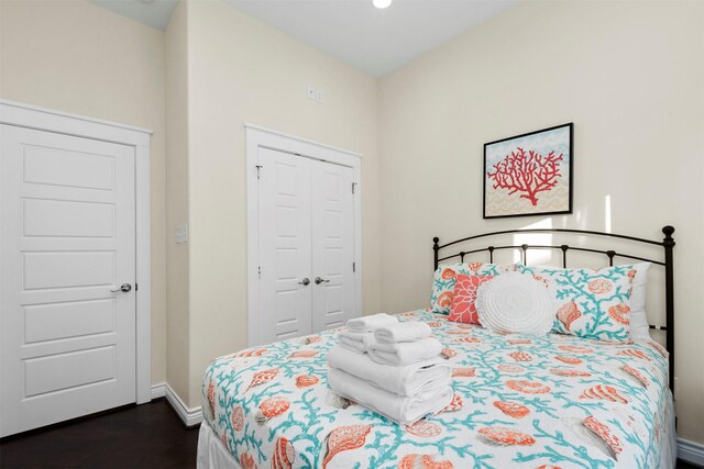 11446 Sea Butterfly, Galveston, TX 77554 - bedroom featuring dark wood-type flooring, baseboards, and a closet