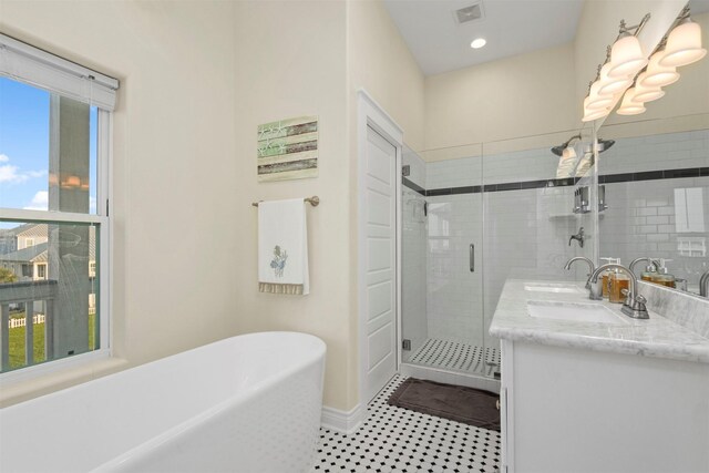 11446 Sea Butterfly, Galveston, TX 77554 - bathroom featuring a stall shower, double vanity, a soaking tub, recessed lighting, and baseboards