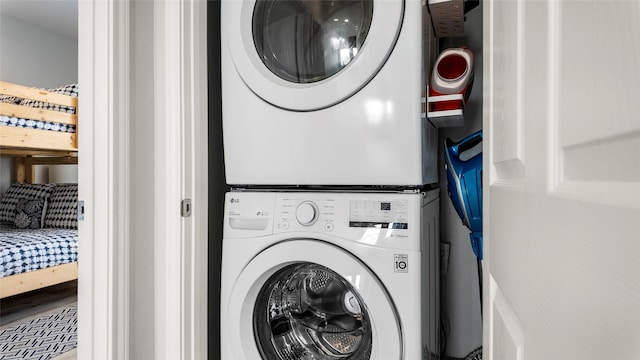 clothes washing area with stacked washer / dryer