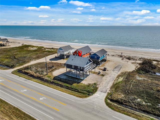 birds eye view of property featuring a water view and a beach view