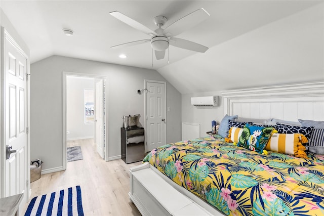 bedroom featuring ceiling fan, lofted ceiling, a wall mounted AC, and light hardwood / wood-style flooring