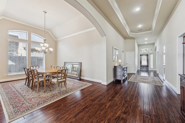 foyer with crown molding, vaulted ceiling, dark hardwood / wood-style floors, and an inviting chandelier