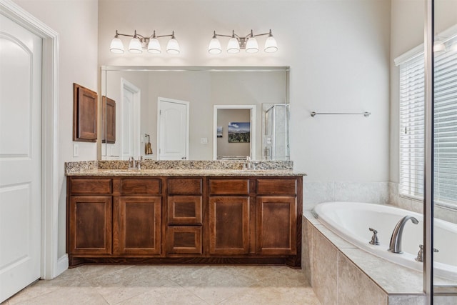 bathroom featuring vanity, tile patterned floors, and tiled bath