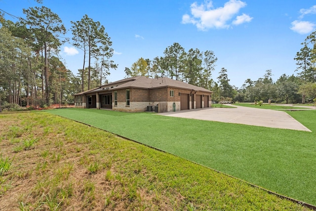 exterior space with a garage, a yard, and central air condition unit