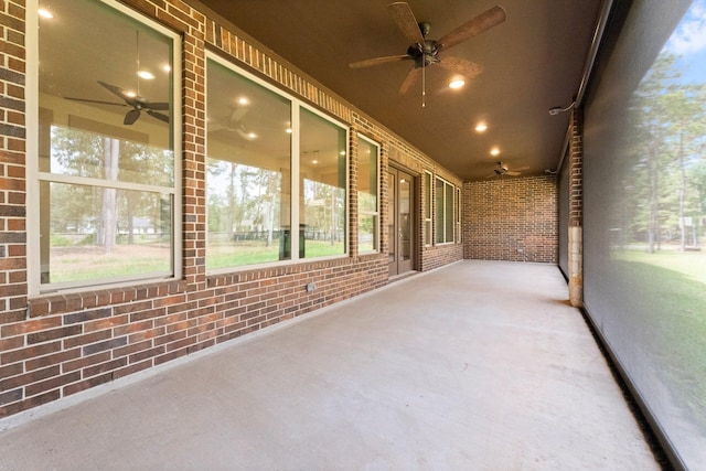 unfurnished sunroom featuring ceiling fan