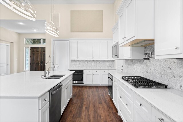 kitchen with sink, white cabinetry, an island with sink, pendant lighting, and stainless steel appliances