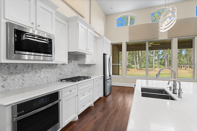 kitchen featuring tasteful backsplash, appliances with stainless steel finishes, sink, and white cabinets