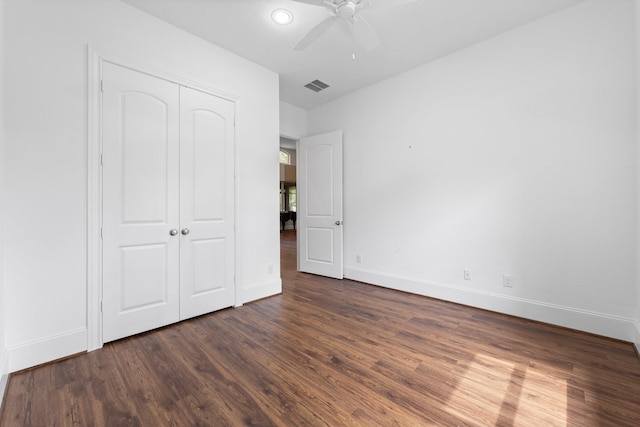 unfurnished bedroom with a closet, dark hardwood / wood-style floors, and ceiling fan