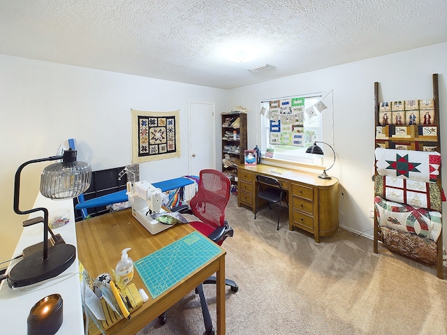 home office featuring light colored carpet, visible vents, and a textured ceiling