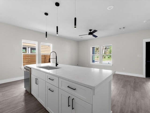 kitchen featuring sink, light stone counters, an island with sink, white cabinets, and stainless steel dishwasher