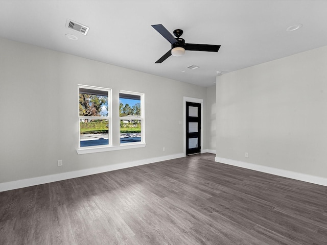 empty room with ceiling fan and dark hardwood / wood-style flooring