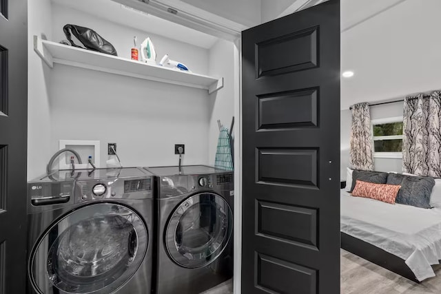 laundry area featuring washer and clothes dryer and light wood-type flooring