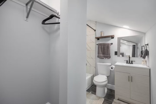 full bathroom featuring tiled shower / bath combo, vanity, wood-type flooring, and toilet