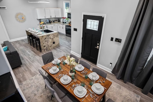 dining room with sink and light wood-type flooring