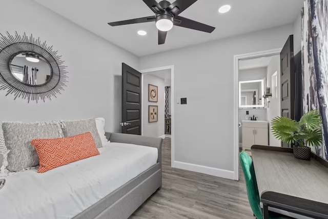 bedroom with hardwood / wood-style flooring, ceiling fan, and sink