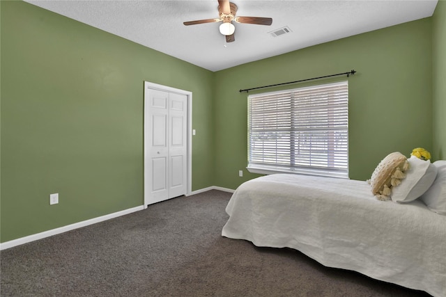 carpeted bedroom featuring a textured ceiling and ceiling fan