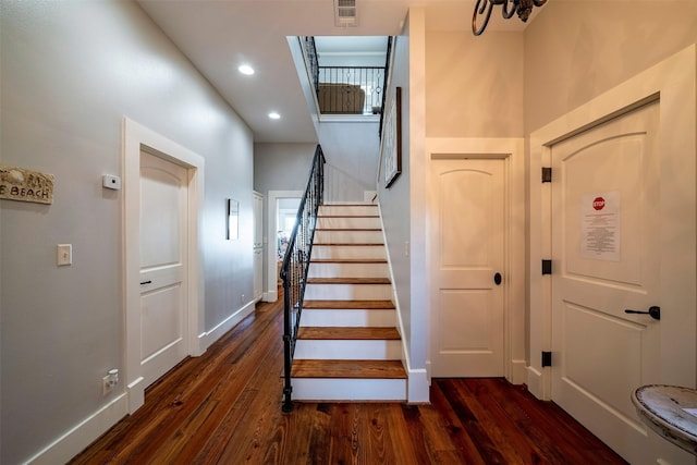 stairs with a high ceiling and wood-type flooring