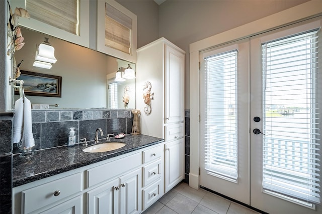 bathroom featuring french doors, vanity, tile patterned flooring, and decorative backsplash