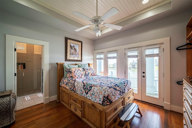 bedroom featuring access to exterior, dark wood-type flooring, french doors, and a raised ceiling