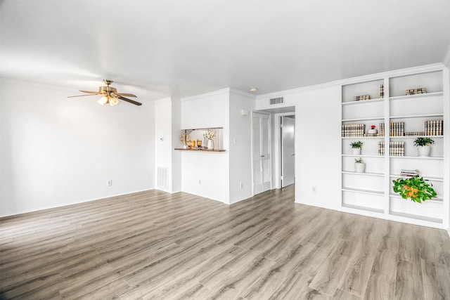 unfurnished living room with built in features, ceiling fan, and light wood-type flooring