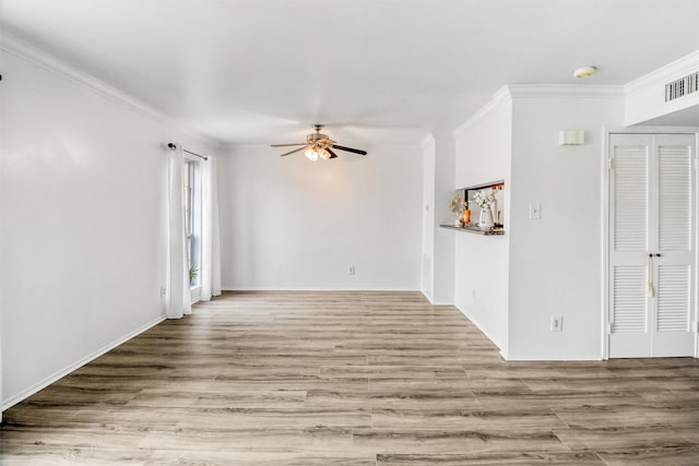 empty room featuring crown molding, ceiling fan, and light wood-type flooring