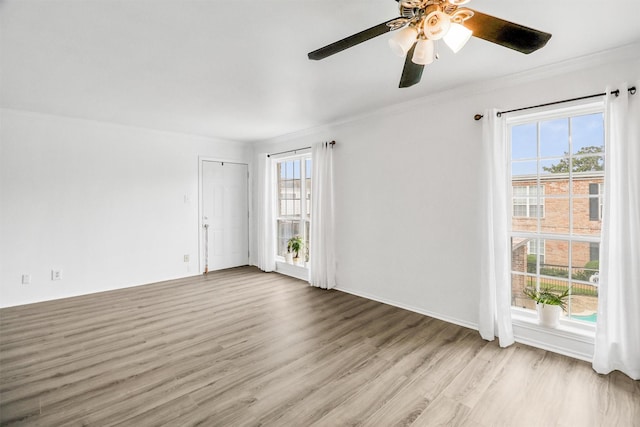 unfurnished room featuring light hardwood / wood-style flooring, plenty of natural light, and ornamental molding